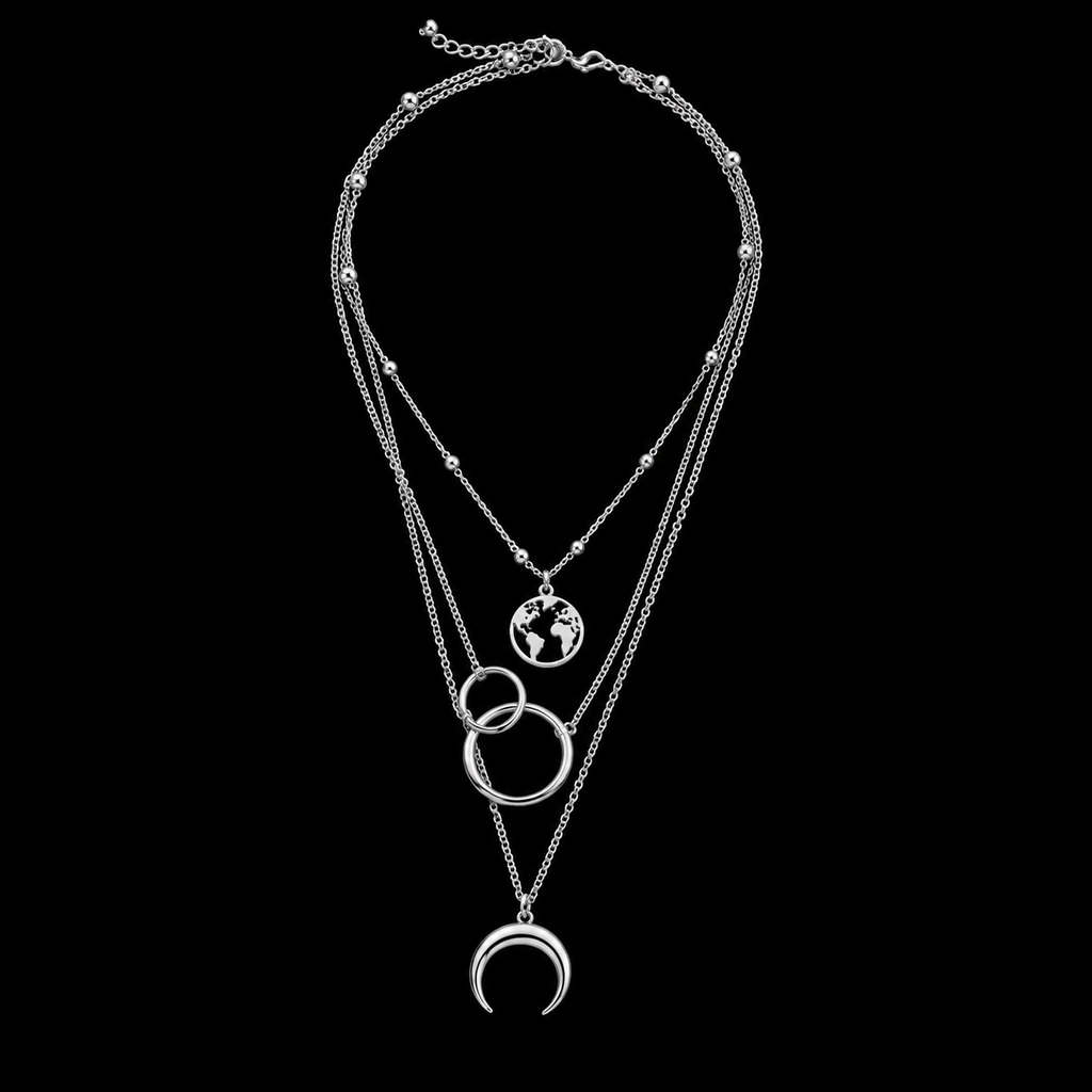 Silver moon and world map necklace flat lay on black background